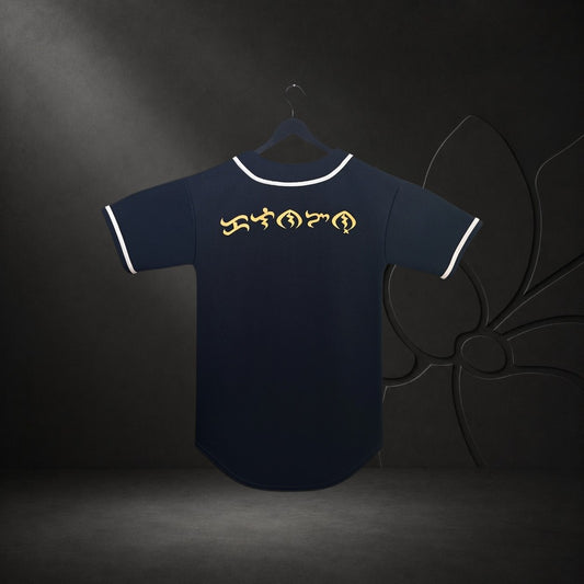 KA'EO Apparel black baseball jersey featuring gold Baybayin script on the back with white piping on a hanger