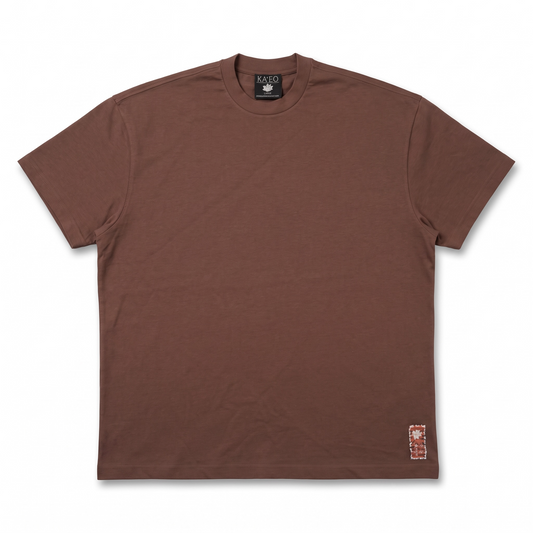 KA'EO Apparel brown cotton Sariah Goddess shirt with a small decorative patch accent near the hem