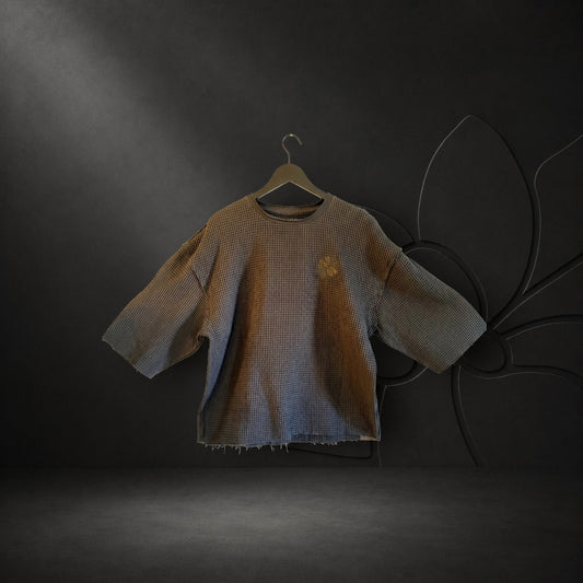 KA'EO Apparel black cropped waffle knit Sampa top with short sleeves and subtle chest embroidery on a hanger.