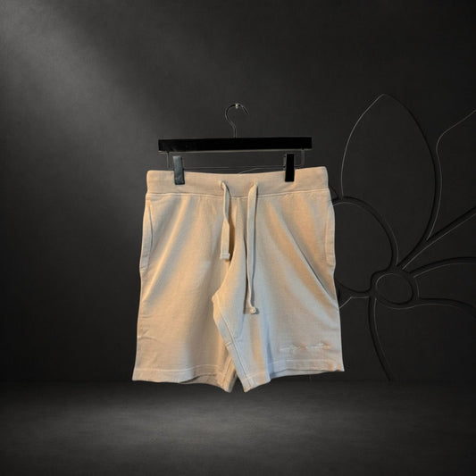 KA'EO Apparel vintage wash distressed gray cotton shorts with an elastic drawstring waistband and raw hem detail.