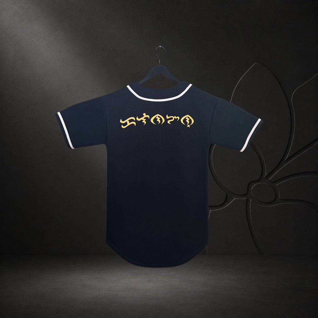 KA'EO Apparel black baseball jersey featuring gold Baybayin script on the back with white piping on a hanger