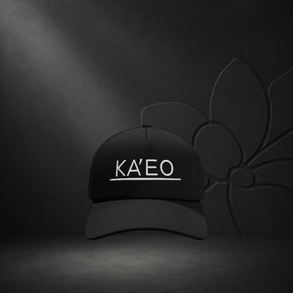 Black KA'EO Apparel snapback cap with white embroidered logo and underline detail. Structured brim, mid-profile fit.