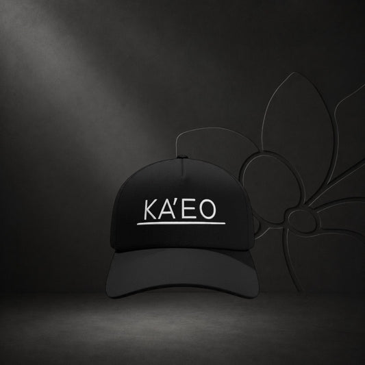 Black KA'EO Apparel snapback cap with white embroidered logo and underline detail. Structured brim, mid-profile fit.