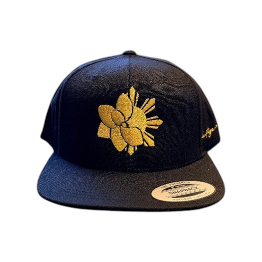 KA'EO Apparel black snapback cap featuring a gold embroidered sampaguita flower design and flat brim.