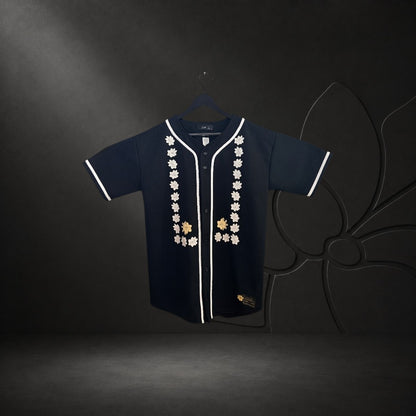 KA'EO Apparel black baseball jersey featuring white piping and intricate Sampaguita floral embroidery on the front.