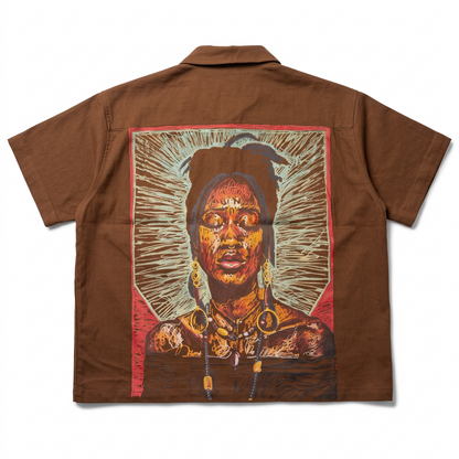 KA'EO Apparel brown cotton short-sleeve button-up shirt featuring a vibrant artistic portrait graphic on the back.