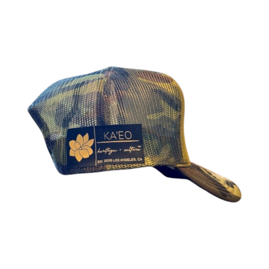 KA'EO Apparel Camo Sampa foam trucker hat featuring a camouflage pattern, mesh back, and side branded patch.