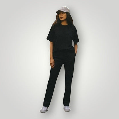 KA'EO Apparel gray embroidered snapback cap worn by a woman in a tropical forest setting.