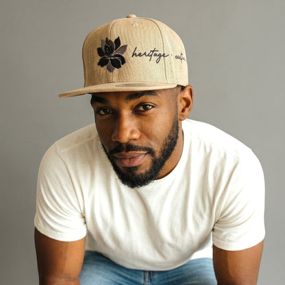 KA'EO Apparel gray snapback hat with embroidered Sampaguita flower and "heritage + culture" text.