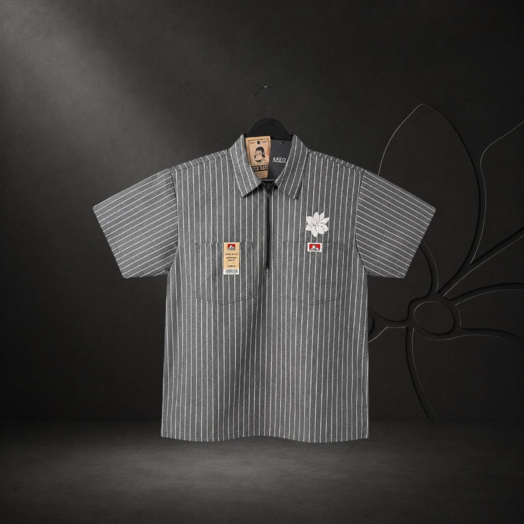 KA'EO Apparel grey pinstripe short-sleeve butcher shirt with quarter-zip, two chest pockets, and floral embroidery.