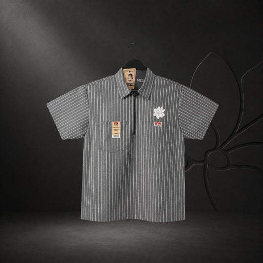 KA'EO Apparel grey pinstripe short-sleeve butcher shirt with quarter-zip, two chest pockets, and floral embroidery.