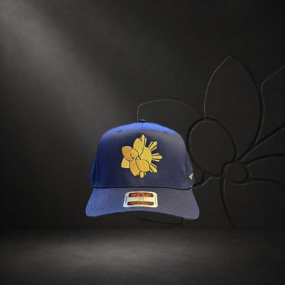 KA'EO Apparel navy blue snapback hat with gold embroidered Sampa-Sol symbol and "heritage + culture" script.