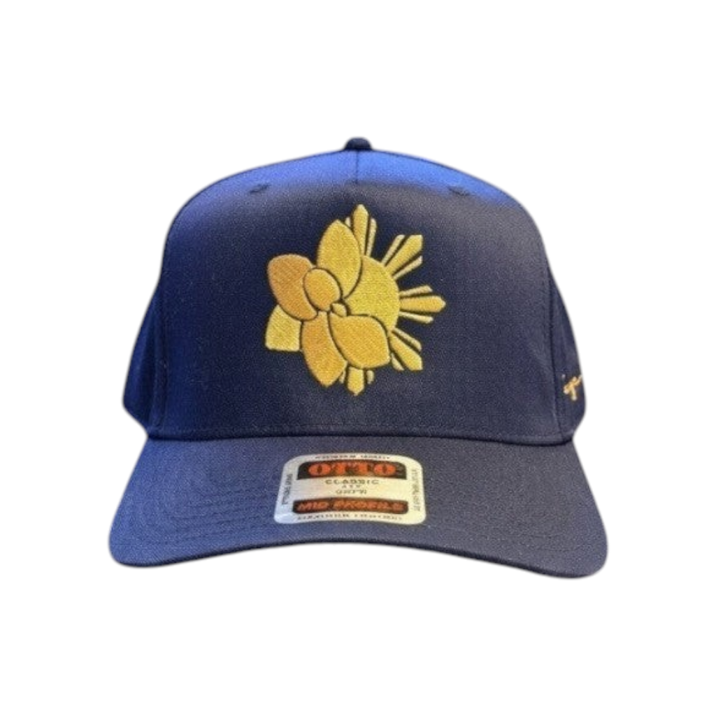 KA'EO Apparel navy blue snapback hat with gold embroidered Sampa-Sol symbol and "heritage + culture" script.